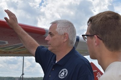 Civil Air Patrol member gesturing at airplane